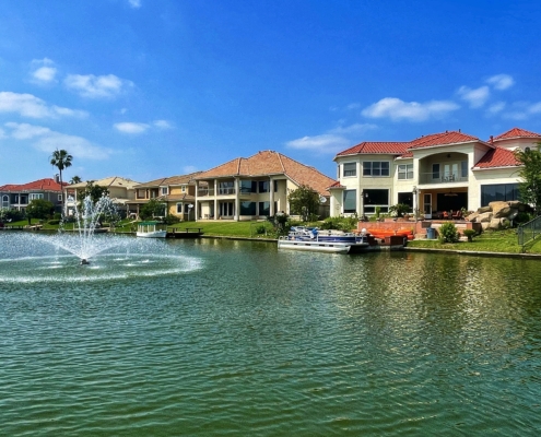Waterfront homes along a canal with a fountain
