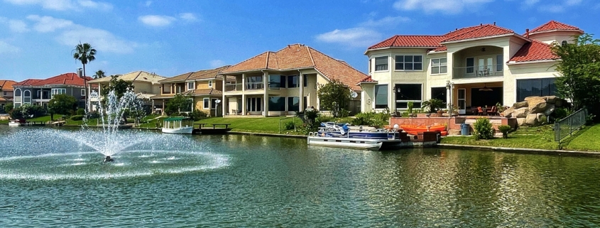 Waterfront homes along a canal with a fountain
